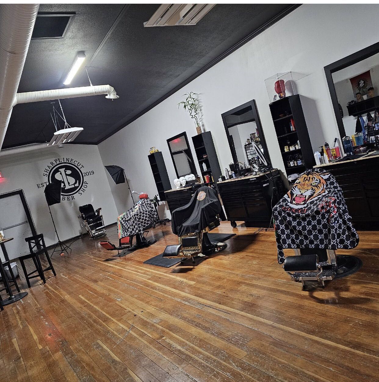 The interior of Sharplinecut Barbershop in Moose Jaw with barber chairs, mirrors and hardwood floors
